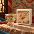 Flying Apsaras ceramic incense vessel beside its illustrated presentation box.